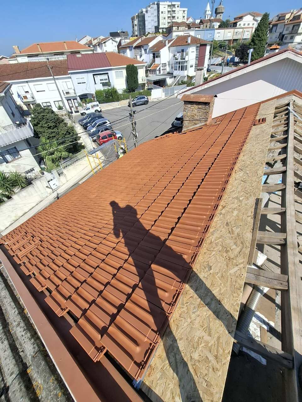 Instalação de telha cerâmica nova, com vista sobre a cidade