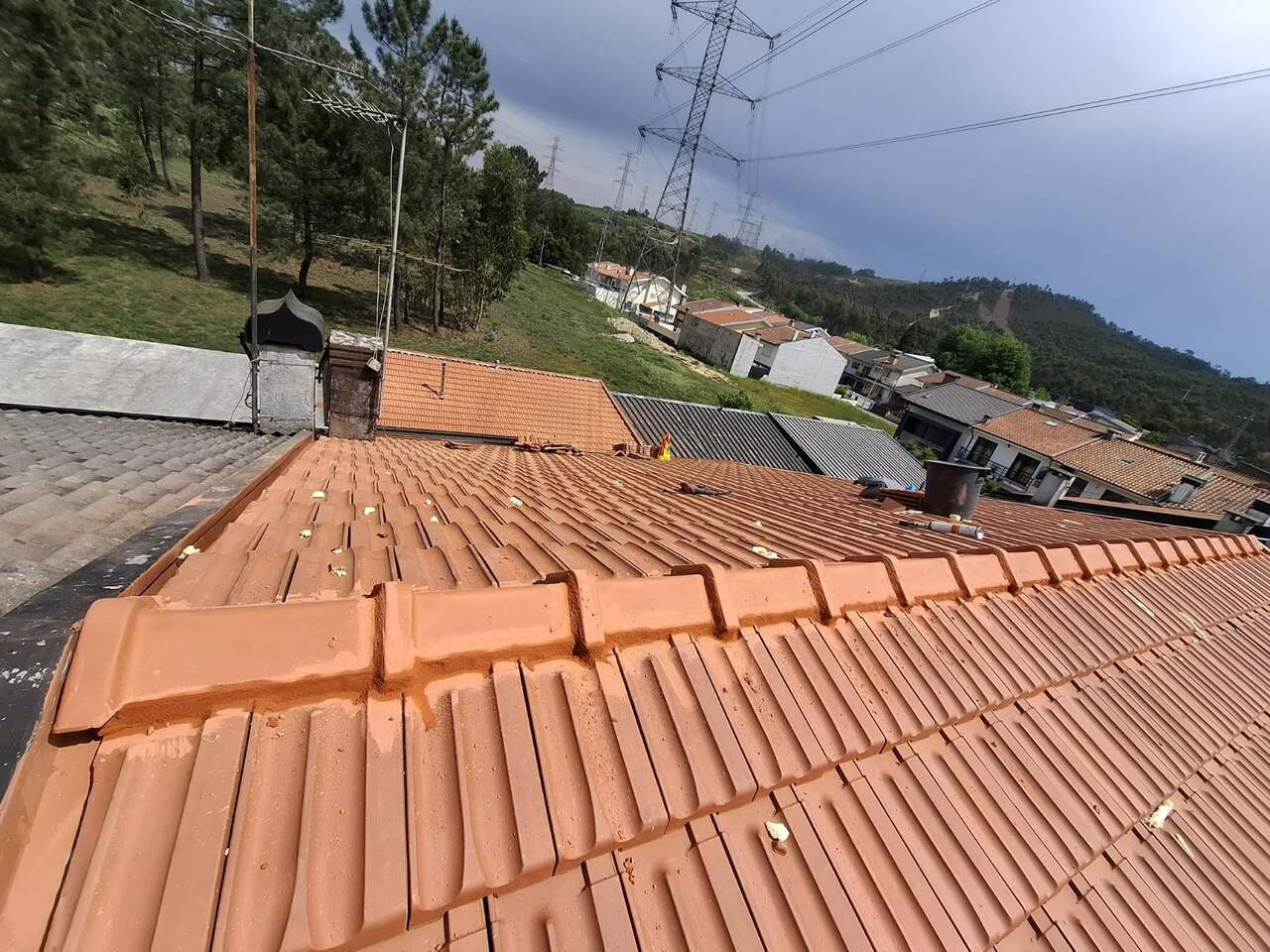 Detalhe de telha cerâmica nova com céu carregado ao fundo
