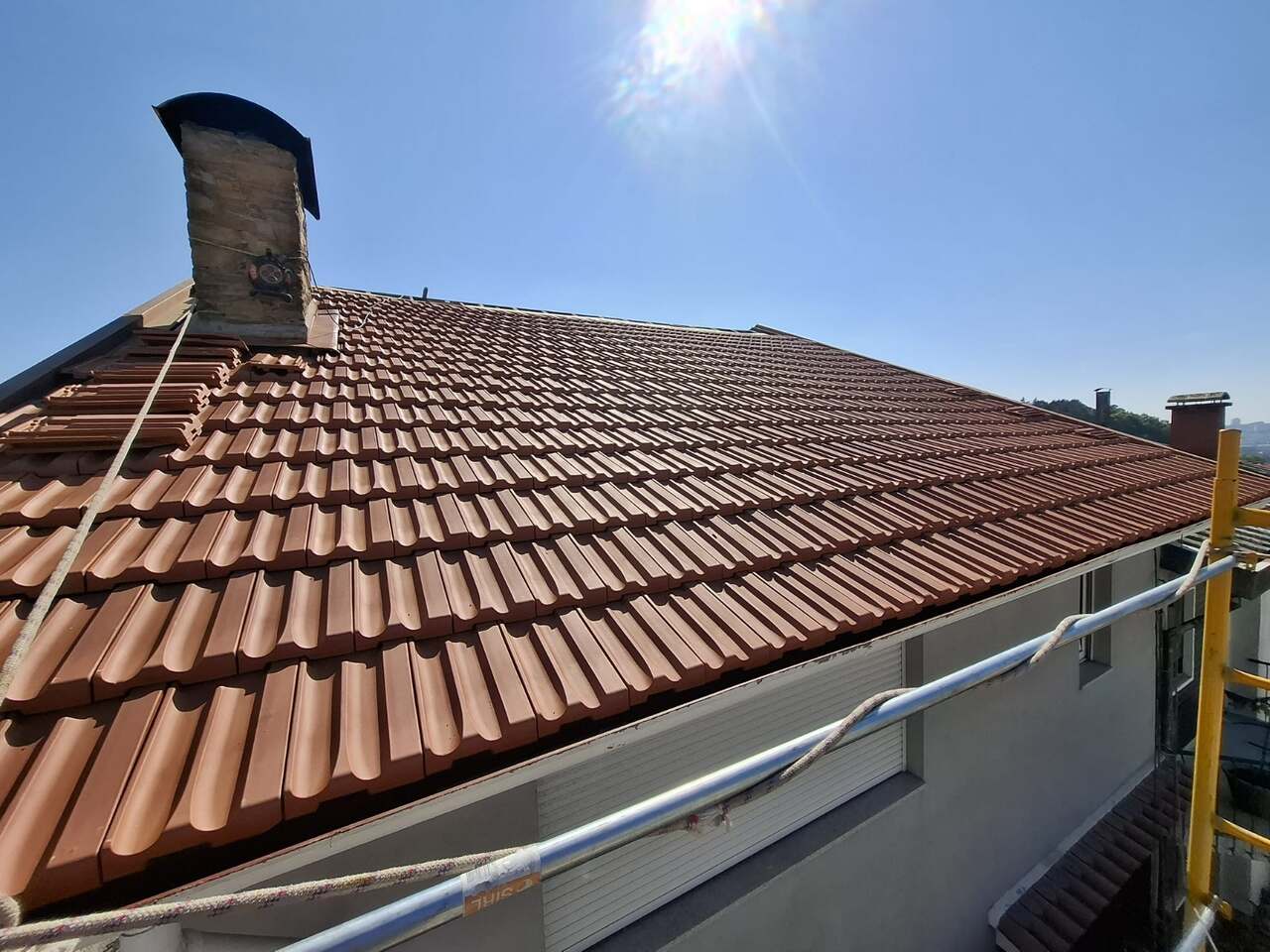 Telhado novo acabado em telha cerâmica, ao sol da manhã