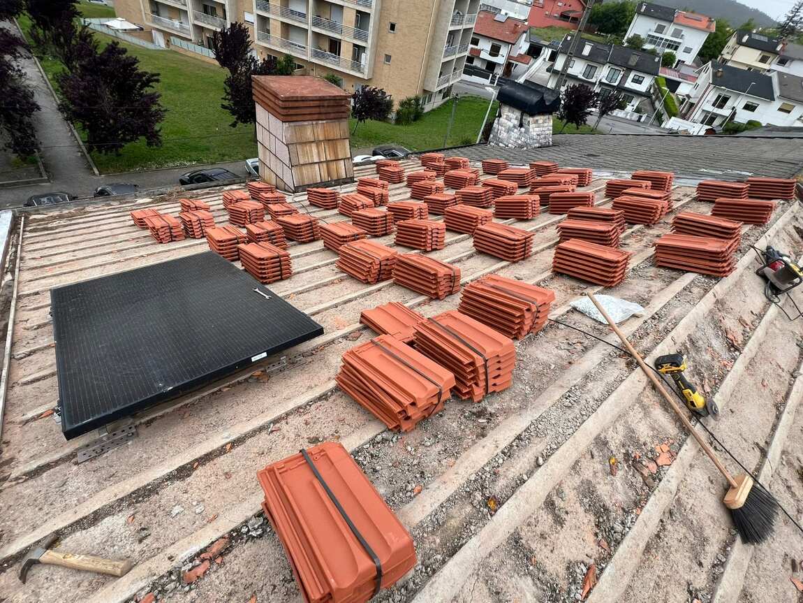 Telhas cerâmicas novas empilhadas no telhado, prontas a instalar